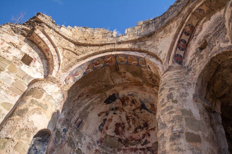 Ruined stone church interior with ancient 6th-century frescoes