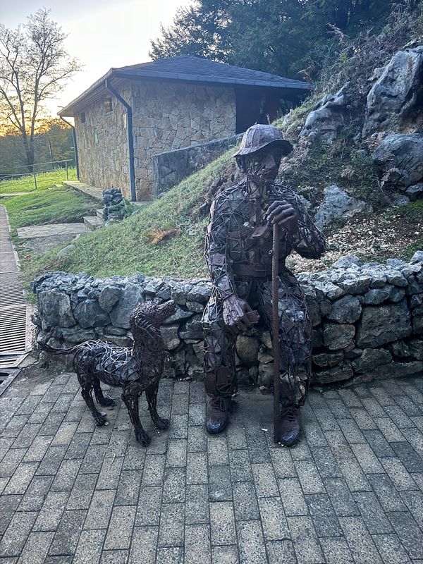 Metal sculpture of a soldier with a dog on the street