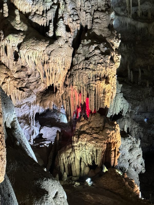 Cave chamber with stalagmites lit in red lighting