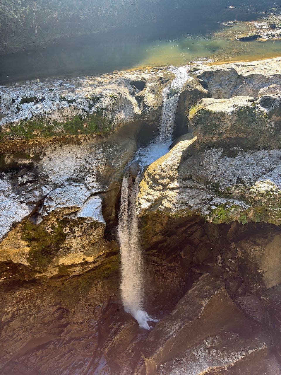 Tall waterfall cascading down rocky canyon walls
